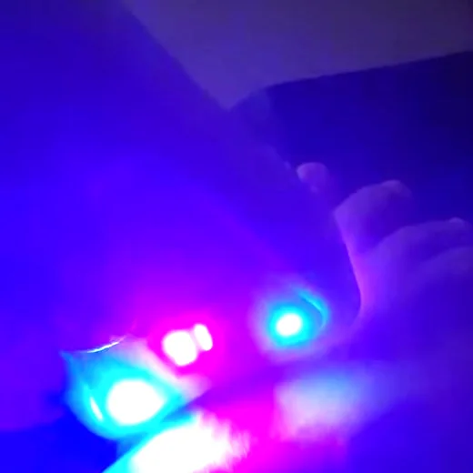 A caneta de laser acesa, em luz vermelha e violeta, sobre o tornozelo da Valdeiza